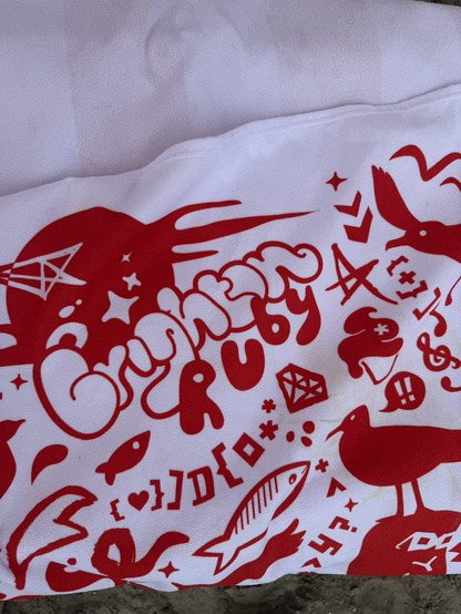 A red and white towel with Brighton Ruby printed on it