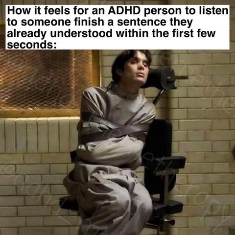 The image shows a person sitting in a chair, bound with straps, wearing a gray prison jumpsuit. The individual is seated against a wall with a window featuring a wire mesh. The person appears to be in a state of contemplation or resignation. The text overlay at the top of the image reads: "How it feels for an ADHD person to listen to someone finish a sentence they already understood within the first few seconds." The background is a plain, light-colored brick wall, and the overall tone of the image is somber.