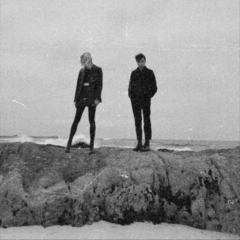 Secret Attraction, Evening Blue album cover. Monochrome shot of two persons standing on a rock near an ocean. No text, colour.