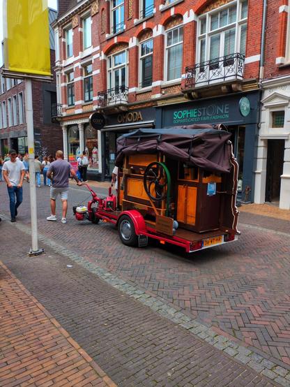 A man rolls a self-playing organ down the street to attract visitors to the museum.