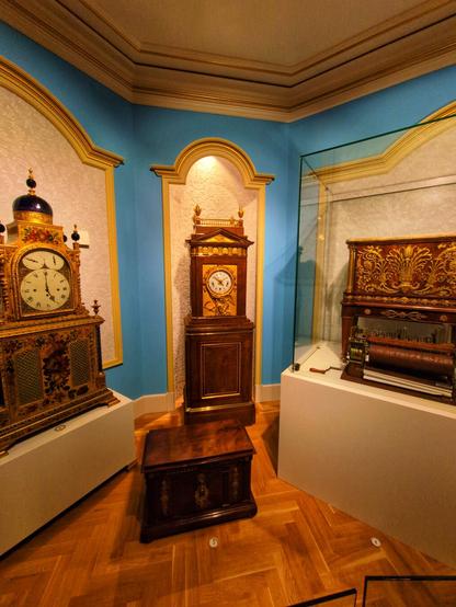 A collection of antique clocks that had been owned by Dutch royalty, in a light blue room with gold leaf details.