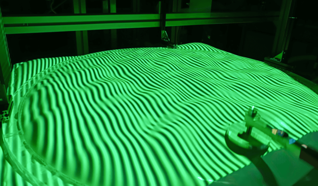 A thin elastic membrane stretched over a water tank shows large-scale wave structures formed from random small-scale fluctuations.
