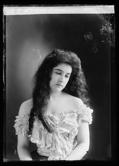 Lady with beautiful curly long har, posing with it down, 1890s. Glass negative.