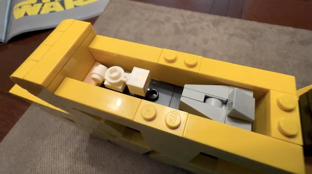 Hidden compartment inside the top of the logo concealing a tiny rebel blockade runner and star destroyer.