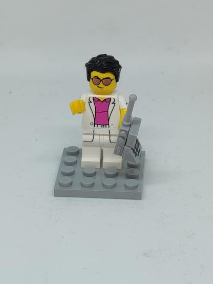 Eine Lego-Minifigur im 80er-Jahre Yuppie-Style mit riesigem Mobiltelefon in der Hand.