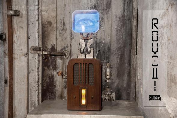 A device composed of an art deco wooden radio body and a 4" black and white functioning TV screen mounted on top.