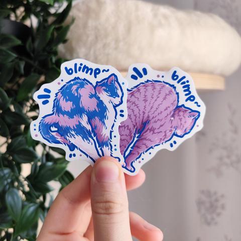 Hand holding up two sticker of a calico and a tabby cat, both stretching, titled "blimp"