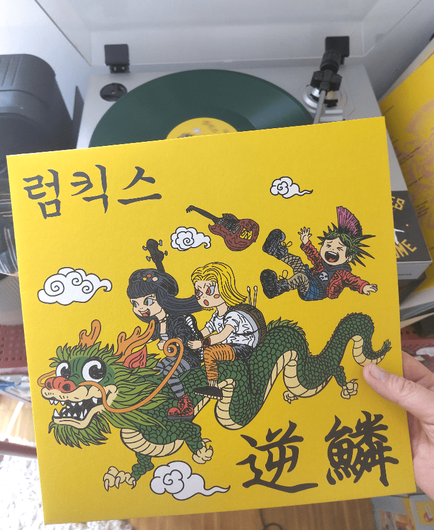 yellow cover, comic style, a green korean or japanish styled dragon, on our the 3  musicians