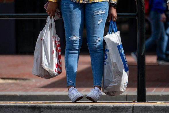 A shopper carries bags in San Francisco, Calif.