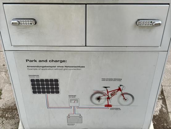A charging station for bicycles is depicted, featuring two lockable compartments. The station includes a solar panel illustration, a solar regulator, and an inductive charging pad for electric bicycles. The text is in English and German, describing the station's functionality.