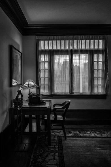 Desk with lamp and typewriter by a curtained window in a San Francisco apartment decorated with furniture from the 1920s.