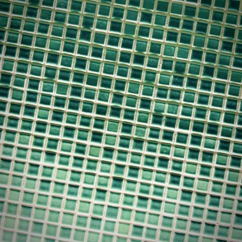 Small green floor tiles fill the frame in a slightly diagonal grid.
