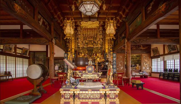 Decorated temple altar. Elaborate gold embellishments hang down from the ceiling before the principal image of worship.

Photo thanks - https://gonjyouin.com https://chion-in.or.jp