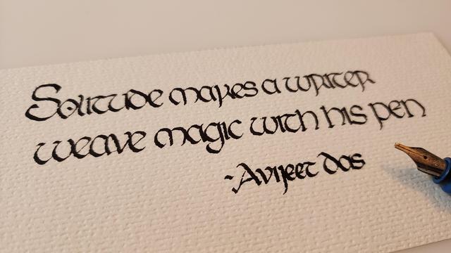 'Solitude makes a writer weave magic with his pen - Avijeet Das' calligraphed in black ink insular script