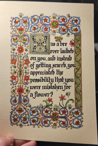 "Has a bee ever landed on you, and instead of getting scared, you appreciated the possibility that you were mistaken for a flower?" calligraphied in blackletter script in dark ink.

The first 'H' of the sentence is ornamental, in its own gold box, and is a chunky black letter filled with little leaves. 

The whole piece is surrounded by a border of swirling vines and flowers in blue, green, and red; in thick bars on the top, bottom, and left, with little bees hovering around the flowers, and then a narrower bar down the right of green swirling vines on a brown background, outlined in gold.