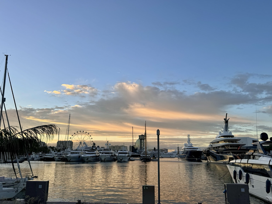 Peach sunrise beneath blue skies over Port Vell in Barcelona