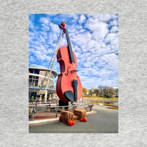 The World’s Largest Fiddle located on the Sydney waterfront next to the Joan Harriss Cruise Pavilion greets visitors as they arrive via cruise ship. The fiddle and bow reach a height of 60 feet!"
Made of solid steel, the giant fiddle was dubbed FIDHEAL MHOR A’ CEILIDH or the “Big Fiddle of the Ceilidh”. Ceilidh is a Gaelic word which translates into "visit."
The Big Fiddle, as many call it, was designed and constructed by Cyril Hearn in 2005. It is a tribute to the folk music and traditions of the province’s Celtic community.
Photography by Debra Martz The World’s Largest Fiddle located on the Sydney waterfront next to the Joan Harriss Cruise Pavilion greets visitors as they arrive via cruise ship. The fiddle and bow reach a height of 60 feet!"
Made of solid steel, the giant fiddle was dubbed FIDHEAL MHOR A’ CEILIDH or the “Big Fiddle of the Ceilidh”. Ceilidh is a Gaelic word which translates into "visit."
The Big Fiddle, as many call it, was designed and constructed by Cyril Hearn in 2005. It is a tribute to the folk music and traditions of the province’s Celtic community.
Photography by Debra Martz
