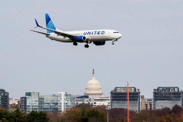 A United Airlines flight lands in front of the US Capitol at Ronald Reagan Washington National Airport as the Trump administration warns of impending cuts to commercial airline operations more than a month into the continuing US government shutdown in Arlington, Virginia, US, on Nov. 7, 2025.
