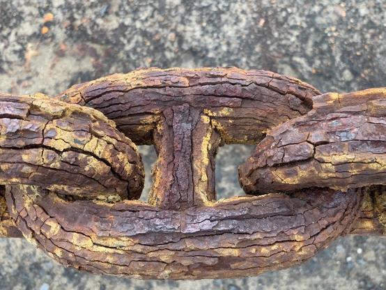 3 rusted large links of a chain
