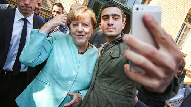 Chancellor Angela Merkel and Anas Modamani, a refugee from Syria, in Berlin in 2015. | Foto: Sean Gallup / Getty Images