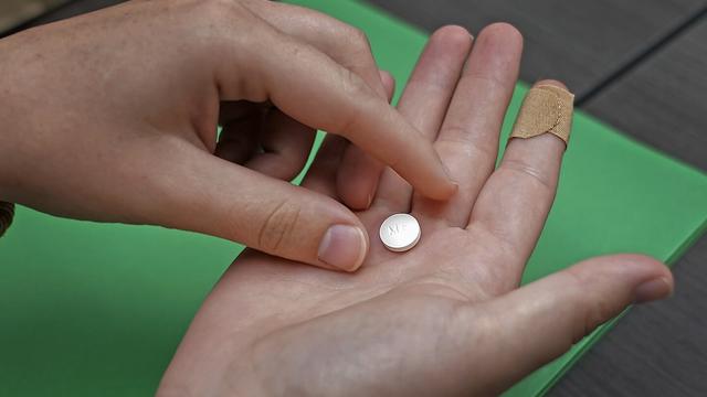 A patient prepares to take the first of two combination pills, mifepristone, for a medication abortion during a visit to a clinic in Kansas City, Kan., Oct. 12, 2022. (AP Photo/Charlie Riedel, File)