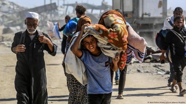 Familien vor zerstörten Häusern als sie nach dem Waffenstillstand nach Chan Junis zurückkehren Familien vor zerstörten Häusern als sie nach dem Waffenstillstand nach Chan Junis zurückkehren
