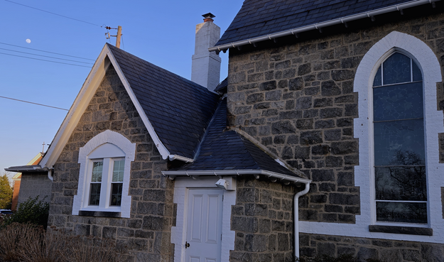 Small distant near-full moon at upper left over a beautiful 19th-century stone chapel. Evening light with the sky a dimming blue, no clouds. We see the left back end of the chapel, showing a smaller window and white wooden door. Toward the right of the frame is one large stained glass window in a pointed arch frame. Mood is quiet, admiring the antique stonework and evening coming on. 

Historic St. Mark's Catholic Church, 2025 Mar 11 06:30 pm EDT. Color photo by @KronoMoon

www.KronoMoon.org 🏳️‍🌈 ☮️ 
#KronoMoon #MoonOverMastodon #KronoWatch 