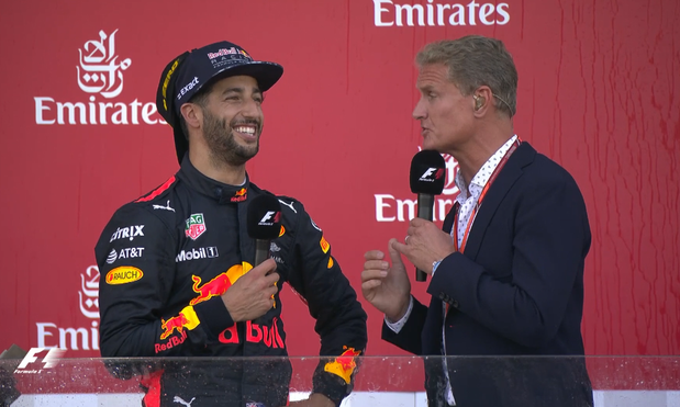 A very smiley Daniel Ricciardo on the podium talking to David Coulthard after a surprise victory. He's wearing 2 caps, because he's a dork and grabbed Max's cap instead of his own, and put the Pirelli victory cap on over top backwards.